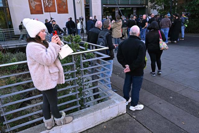 Local residents watch members of the media work outside the Latrobe Valley Magistrates' Court in Morwell on July 7, 2025. An Australian woman murdered her husband's parents and aunt by lacing their beef Wellington lunch with toxic mushrooms, a jury found on July 7 at the climax of a trial watched around the world. Keen home cook Erin Patterson hosted an intimate meal in July 2023 that started with good-natured banter and earnest prayer -- but ended with three guests dead. (Photo by WILLIAM WEST / AFP)