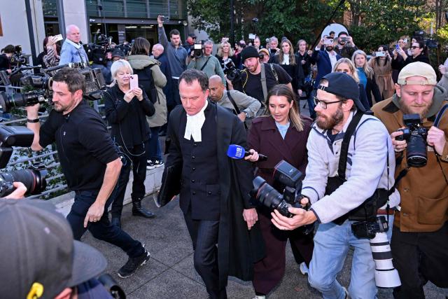 TOPSHOT - Lead barrister Colin Mandy (C) is surrounded by members of the media as he leaves the Latrobe Valley Magistrates' Court in Morwell on July 7, 2025. An Australian woman murdered her husband's parents and aunt by lacing their beef Wellington lunch with toxic mushrooms, a jury found on July 7 at the climax of a trial watched around the world. Keen home cook Erin Patterson hosted an intimate meal in July 2023 that started with good-natured banter and earnest prayer -- but ended with three guests dead. (Photo by WILLIAM WEST / AFP)