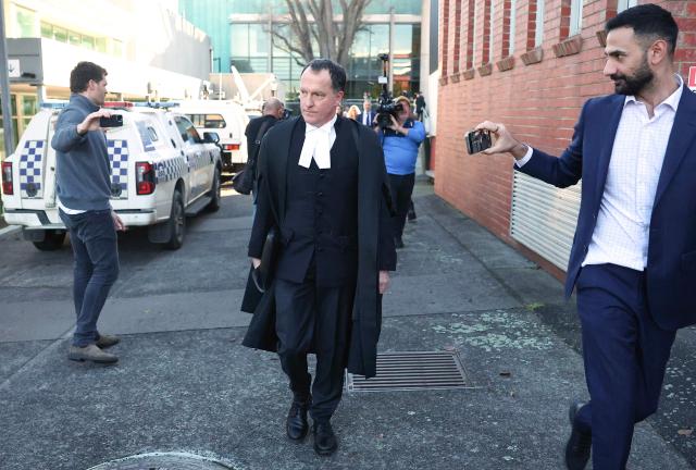 Lead barrister Colin Mandy (C) is followed by members of the media as he leaves the Latrobe Valley Magistrates' Court in Morwell on July 7, 2025. An Australian woman murdered her husband's parents and aunt by lacing their beef Wellington lunch with toxic mushrooms, a jury found on July 7 at the climax of a trial watched around the world. Keen home cook Erin Patterson hosted an intimate meal in July 2023 that started with good-natured banter and earnest prayer -- but ended with three guests dead. (Photo by MARTIN KEEP / AFP)