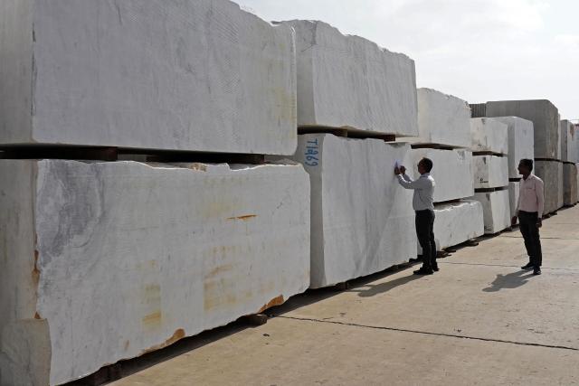 Workers inspect imported stones at a marble factory in Kishangarh, in India's Rajasthan state on July 8, 2025. New Delhi and Washington have been locked in multiple rounds of talks, with hopes for an interim pact to avert the 26 percent "reciprocal" tolls meted out to India. (Photo by HIMANSHU SHARMA / AFP)