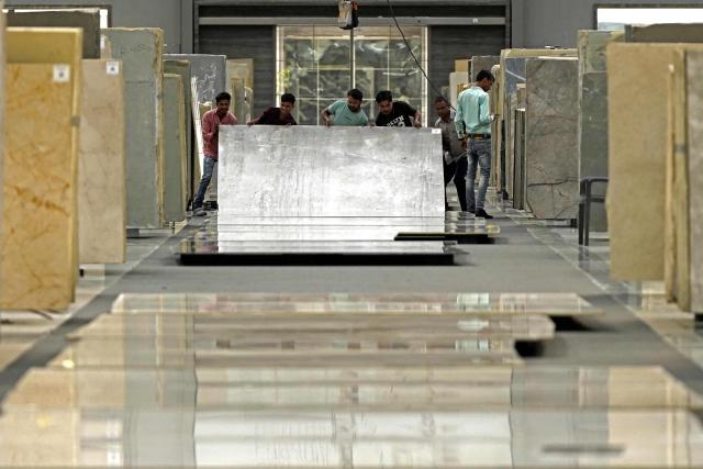 Workers inspect imported stones at a marble factory in Kishangarh, in India's Rajasthan state on July 8, 2025. New Delhi and Washington have been locked in multiple rounds of talks, with hopes for an interim pact to avert the 26 percent "reciprocal" tolls meted out to India. (Photo by HIMANSHU SHARMA / AFP)