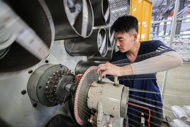 An employee works on a production line of tubular products for export at a factory in Lianyungang, in eastern China's Jiangsu province on July 8, 2025. US President Donald Trump reignited his trade war by threatening more than a dozen countries with higher tariffs on July 7 -- but then said he may be flexible on his new August deadline to reach deals. So far only two firm deals have emerged, with Britain and Vietnam, plus an agreement to dial back super-high tit-for-tat tariffs with China. (Photo by AFP) / China OUT