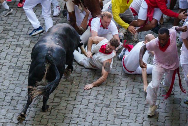 A runner falls as he is hit by a bull during the second running of the bulls of the San Fermin festival in Pamplona, northern Spain, on July 8, 2025. Thousands of people every year attend the week-long festival and its famous "encierros" or bull runs, every day at 8:00 a.m. through the narrow streets of the old town over an 850 meters (yard) course while runners ahead of them try to stay close to the bulls without falling over or being gored. (Photo by CESAR MANSO / AFP)