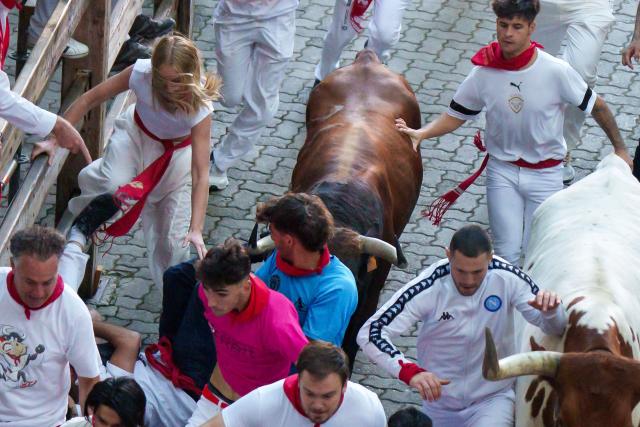 Participants run ahead of bulls during the second running of the bulls of the San Fermin festival in Pamplona, northern Spain, on July 8, 2025. Thousands of people every year attend the week-long festival and its famous "encierros" or bull runs, every day at 8:00 a.m. through the narrow streets of the old town over an 850 meters (yard) course while runners ahead of them try to stay close to the bulls without falling over or being gored. (Photo by CESAR MANSO / AFP)