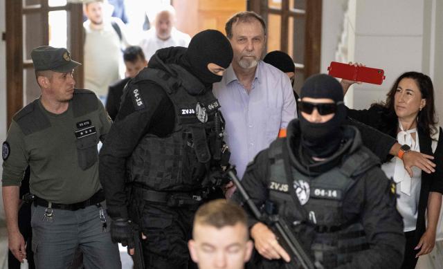 Police escort Juraj Cintula (C), a 72-year-old poet, into the courtroom in Banska Bystrica, Slovakia, on July 8, 2025, for the start of his trial where he is accused of shooting Slovakia's Prime Minister Robert Fico (unseen) on May 15, 2024. The man who admitted to shooting Slovak Prime Minister Robert Fico is due to stand trial on terror charges on July 7, 2025 in the central Slovak city of Banska Bystrica, more than a year after the attack shocked the central European country. Detained at the scene, Juraj Cintula, a 72-year-old poet, who has admitted to shooting the leader with the intention to wound but not kill him, is facing up to life in prison if convicted. (Photo by Joe Klamar / AFP)