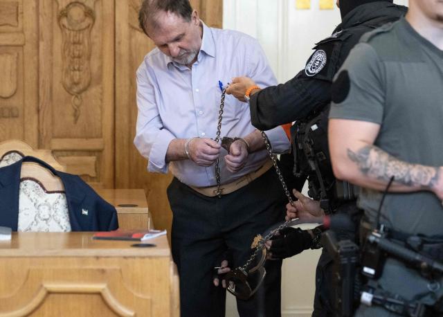 Defendant Juraj Cintula, a 72-year-old poet, gets his handcuffs removed as he arrives in the courtroom in Banska Bystrica, Slovakia, on July 8, 2025, before the start of his trial where he is accused of shooting Slovakia's Prime Minister Robert Fico (unseen) on May 15, 2024. The man who admitted to shooting Slovak Prime Minister Robert Fico is due to stand trial on terror charges on July 7, 2025 in the central Slovak city of Banska Bystrica, more than a year after the attack shocked the central European country. Detained at the scene, Juraj Cintula, a 72-year-old poet, who has admitted to shooting the leader with the intention to wound but not kill him, is facing up to life in prison if convicted. (Photo by Joe Klamar / AFP)