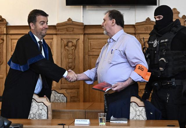 Defendant Juraj Cintula (R), a 72-year-old poet, greets his lawyer Namir Alyastry (L) in the courtroom in Banska Bystrica, Slovakia, on July 8, 2025, before the start of his trial where he is accused of shooting Slovakia's Prime Minister Robert Fico (unseen) on May 15, 2024. The man who admitted to shooting Slovak Prime Minister Robert Fico is due to stand trial on terror charges on July 7, 2025 in the central Slovak city of Banska Bystrica, more than a year after the attack shocked the central European country. Detained at the scene, Juraj Cintula, a 72-year-old poet, who has admitted to shooting the leader with the intention to wound but not kill him, is facing up to life in prison if convicted. (Photo by Joe Klamar / AFP)