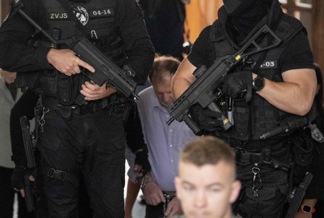 Police with machine guns escort Juraj Cintula (C), a 72-year-old poet, into the courtroom in Banska Bystrica, Slovakia, on July 8, 2025, for the start of his trial where he is accused of shooting Slovakia's Prime Minister Robert Fico (unseen) on May 15, 2024. The man who admitted to shooting Slovak Prime Minister Robert Fico is due to stand trial on terror charges on July 7, 2025 in the central Slovak city of Banska Bystrica, more than a year after the attack shocked the central European country. Detained at the scene, Juraj Cintula, a 72-year-old poet, who has admitted to shooting the leader with the intention to wound but not kill him, is facing up to life in prison if convicted. (Photo by Joe Klamar / AFP)