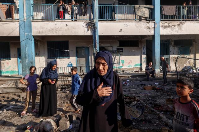 A Palestinian woman reacts as she checks the damages after an Israeli strike which hit a school sheltering displaced Palestinians in the Al-Bureij camp in the central Gaza Strip on July 8, 2025. A third day of indirect negotiations on a Gaza ceasefire between Israel and Palestinian Islamist movement Hamas began in Doha on July 8, a Palestinian source close to the talks said. (Photo by Eyad BABA / AFP)
