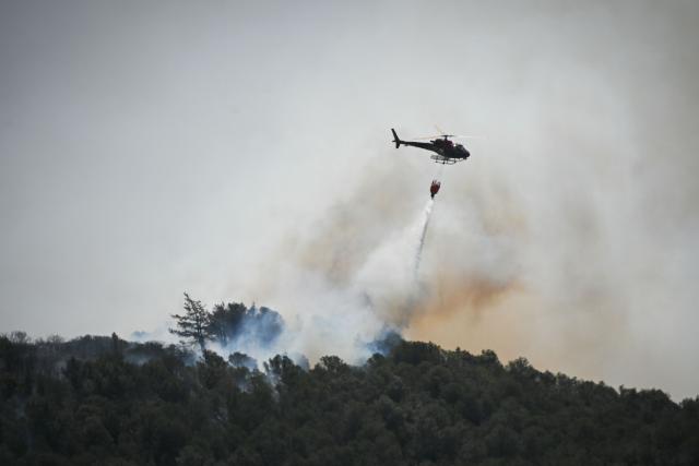 A water bomber helicopter drops water on a forest fire near the Aussieres neighbourhood, close to the city of Narbonne, southwestern France, on July 8, 2025. (Photo by Matthieu RONDEL / AFP)