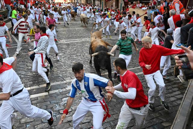 Participants run ahead of Alvaro Nunez bulls during the third running of the bulls of the San Fermin festival in Pamplona, northern Spain, on July 9, 2025. Thousands of people every year attend the week-long festival and its famous "encierros" or bull runs, every day at 8:00 a.m. through the narrow streets of the old town over an 850 meters (yard) course while runners ahead of them try to stay close to the bulls without falling over or being gored. (Photo by Ander GILLENEA / AFP)