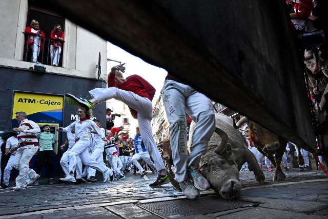 TOPSHOT - Participants run ahead of Alvaro Nunez bulls during the third running of the bulls of the San Fermin festival in Pamplona, northern Spain, on July 9, 2025. Thousands of people every year attend the week-long festival and its famous "encierros" or bull runs, every day at 8:00 a.m. through the narrow streets of the old town over an 850 meters (yard) course while runners ahead of them try to stay close to the bulls without falling over or being gored. (Photo by Ander GILLENEA / AFP)