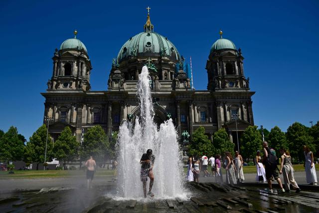 (FILES) People refresh themselves in the cool water of a fountain in front of the Cathedral at the Lustgarten park on Museum Island in Berlin on July 2, 2025, as temperatures were predicted to reach up to 37 degrees Celsius. Human-caused climate change made the recent European heatwave up to 4C hotter in many cities, scientists said on July 9, 2025, pushing temperatures into deadly territory for thousands of vulnerable people. (Photo by John MACDOUGALL / AFP)