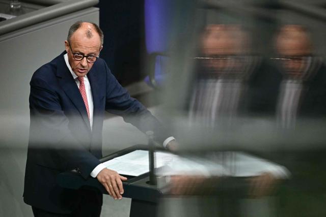 German Chancellor Friedrich Merz is reflected in a balustrade as he addresses parliamentarians during a general debate on the budget of the Chancellery at the Bundestag, the lower house of parliament, in Berlin, on July 9, 2025, while the . (Photo by Tobias SCHWARZ / AFP)