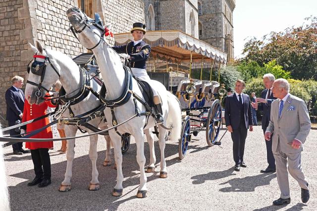 France's President Emmanuel Macron (R) and Britain's King Charles III view the Charabanc horse-drawn carriage which was gifted to Queen Victoria by King Louis-Philippe of France in 1844, at Windsor Castle, in Windsor west of London, on July 9, 2025, on the second day of the President's three-day state visit to Britain. King Charles III and Emmanuel Macron on Tuesday both hailed the importance of UK-France relations as the French president began a three-day formal visit to Britain, the first by an EU head of state since Brexit. (Photo by Aaron Chown / POOL / AFP)