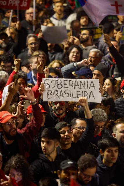 People attend a demonstration calling to tax the super-rich and demanding the end of the six-day workweek at the Paulista Avenue in Sao Paulo, Brazil, on July 10, 2025. The reduction of the workweek to six days started as a popular demand and is now gaining support among politicians. Additionally, the Brazilian federal government has presented a bill proposing a 10% tax on the super-rich, which is currently under discussion in Congress. (Photo by Miguel SCHINCARIOL / AFP)