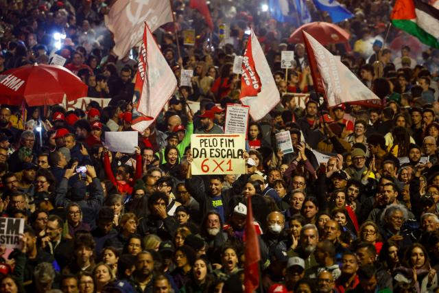 People attend a demonstration calling to tax the super-rich and demanding the end of the six-day workweek at the Paulista Avenue in Sao Paulo, Brazil, on July 10, 2025. The reduction of the workweek to six days started as a popular demand and is now gaining support among politicians. Additionally, the Brazilian federal government has presented a bill proposing a 10% tax on the super-rich, which is currently under discussion in Congress. (Photo by Miguel SCHINCARIOL / AFP)