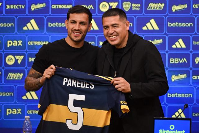 Argentina Boca Juniors' midfielder Leandro Paredes (L) and Argentina's Boca Juniors President Juan Roman Riquelme pose with the jersey in a press conference during Paredes' presentation at La Bombonera Stadium in Buenos Aires on July 10, 2025. Argentine midfielder Leandro Paredes, World Cup champion in Qatar 2022, returned to Boca Juniors, the team where he began his career between 2010 and 2013, before embarking on a European tour that culminated weeks ago at AS Roma. (Photo by Luis ROBAYO / AFP)