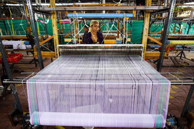 A worker weaves a traditional Banarasi saree on a handloom at a workshop in Ajmer on July 10, 2025. (Photo by Himanshu SHARMA / AFP)
