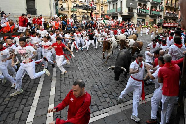Participants run ahead of Jandilla bulls during the fifth running of the bulls of the San Fermin festival in Pamplona, northern Spain, on July 11, 2025. Thousands of people every year attend the week-long festival and its famous "encierros" or bull runs, every day at 8:00 a.m. through the narrow streets of the old town over an 850 meters (yard) course while runners ahead of them try to stay close to the bulls without falling over or being gored. (Photo by ANDER GILLENEA / AFP)