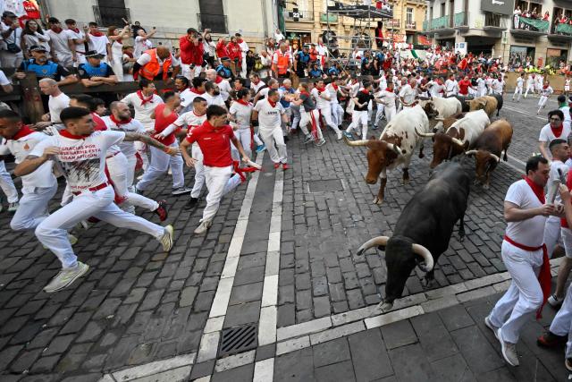 Participants run ahead of Jandilla bulls during the fifth running of the bulls of the San Fermin festival in Pamplona, northern Spain, on July 11, 2025. Thousands of people every year attend the week-long festival and its famous "encierros" or bull runs, every day at 8:00 a.m. through the narrow streets of the old town over an 850 meters (yard) course while runners ahead of them try to stay close to the bulls without falling over or being gored. (Photo by ANDER GILLENEA / AFP)