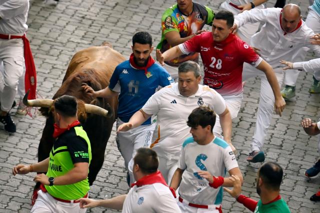 Participants run ahead of Jandilla bulls during the fifth running of the bulls of the San Fermin festival in Pamplona, northern Spain, on July 11, 2025. Thousands of people every year attend the week-long festival and its famous "encierros" or bull runs, every day at 8:00 a.m. through the narrow streets of the old town over an 850 meters (yard) course while runners ahead of them try to stay close to the bulls without falling over or being gored. (Photo by MIGUEL RIOPA / AFP)