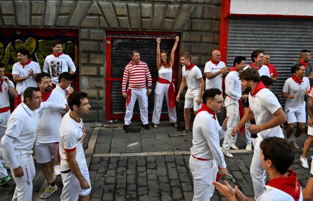 Runners react to the firing of the second rocket, which signals the release of the bulls and the start of the fifth running of the bulls of the San Fermin festival in Pamplona, northern Spain, on July 11, 2025. Thousands of people every year attend the week-long festival and its famous "encierros" or bull runs, every day at 8:00 a.m. through the narrow streets of the old town over an 850 meters (yard) course while runners ahead of them try to stay close to the bulls without falling over or being gored. (Photo by ANDER GILLENEA / AFP)