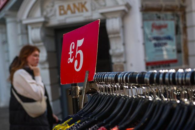 (FILES) A price tag is seen on a rack of clothes in a street market in Portobello road, in west London on February 16, 2024. Britain's economy unexpectedly contracted for a second month in a row in May, official data showed on July 11, 2025, in a blow to Britain's Labour government as it seeks to kickstart growth. Gross domestic product shrank 0.1 percent in May, following a 0.3 percent contraction in April, the Office for National Statistics said in a statement. (Photo by Daniel LEAL / AFP)