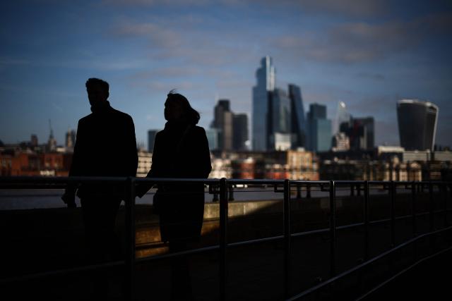 (FILES) People walk on Southbank of the River Thames backdropped by the business and financial district in central London on November 15, 2024. Britain's economy unexpectedly contracted for a second month in a row in May, official data showed on July 11, 2025, in a blow to Britain's Labour government as it seeks to kickstart growth. Gross domestic product shrank 0.1 percent in May, following a 0.3 percent contraction in April, the Office for National Statistics said in a statement. (Photo by HENRY NICHOLLS / AFP)
