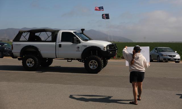 A protestor holds a sign as cars drive by the Glass House Farms in Camarillo, California, on July 11, 2025, a day after an immigration raid on workers. A farmworker has died from injuries sustained during an immigration raid on legal cannabis farms near Los Angeles, where clashes erupted between federal agents and protesters. The man was injured on July 10 and died the following day, July 11.
"The family informed me that he was in intensive care, and this morning they confirmed that he had passed away," Roman Pinal, vice-president of United Farm Workers, told AFP at the scene.
The raid occurred July 10 in Carpinteria and Camarillo, two agricultural communities in Ventura County, about an hour northwest of Los Angeles. (Photo by Patrick T. Fallon / AFP)