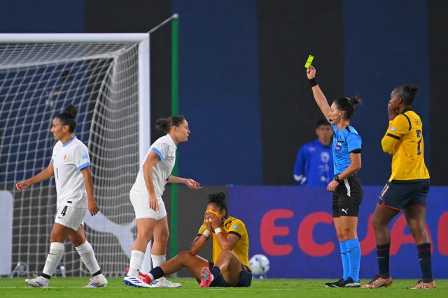 Brazilian referee Daiane Muniz shows a yellow card to Uruguay's defender #04 Carina Felipe (L) during the Women's Copa America 2025 football match between Ecuador and Uruguay at the IDV Stadium in Quito on July 11, 2025. (Photo by Rodrigo BUENDIA / AFP)