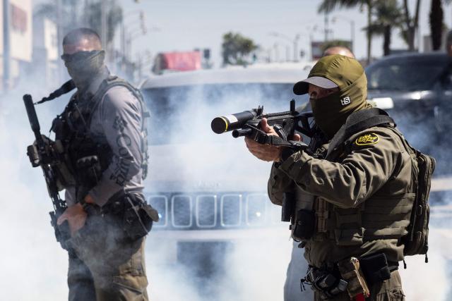 (FILES) US Custom and Border Police (CBP) officers shoot with less lethal ammunitions at community members pushing back against their attempt to raid a store in Bell, just south of Los Angeles, California, on June 20, 2025. A federal judge on July 11 ordered the Trump administration to take measures to prevent racial profiling in Los Angeles, during the violent arrests of migrants that have been increasing in the past month around the Californian metropolis. She ruled in favor of several migrants and two American citizens, as well as the organizations that helped them file a complaint in early July. They claimed they had been victims of racial profiling and also denounced obstructions to accessing legal counsel while in detention. (Photo by ETIENNE LAURENT / AFP)