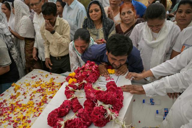 (FILES) Relatives mourn by the coffins of victims, who were killed in the Air India flight AI171 crash, during a special prayer before the funeral ceremony in Ahmedabad on June 15, 2025. Fuel control switches to the engines of an Air India flight that crashed shortly after takeoff, killing 260 people, were moved from the "run" to the "cutoff" position moments before impact, a preliminary investigation report said early on July 12. (Photo by Dibyangshu SARKAR / AFP)