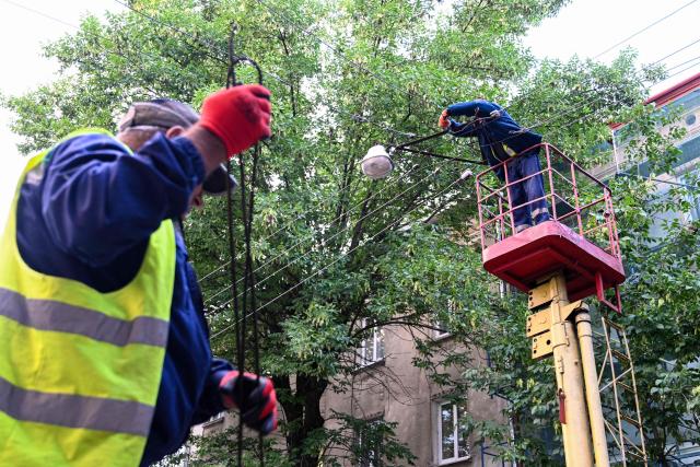 Workers repair power lines following mass Russian drone and missile strikes in the western Ukrainian city of Lviv on July 12, 2025, amid the Russian invasion of Ukraine. (Photo by YURIY DYACHYSHYN / AFP)
