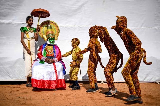 TOPSHOT - A Kathakali classical dancer (2L) watches artists rehearse the traditional folk dance Pulikkali (Tiger Dance) as they wait backstage before their performance at a cultural festival in Chennai on July 12, 2025. (Photo by R. Satish BABU / AFP)