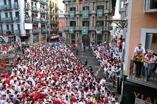A crowd of runners packs the street in front of Pamplona's City Hall before the start of the sixth running of the bulls of the San Fermin festival in Pamplona, northern Spain, on July 12, 2025. Thousands of people every year attend the week-long festival and its famous "encierros" or bull runs, every day at 8:00 a.m. through the narrow streets of the old town over an 850 meters (yard) course while runners ahead of them try to stay close to the bulls without falling over or being gored. (Photo by MIGUEL RIOPA / AFP)