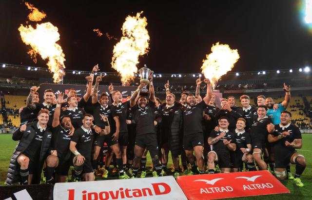Mew Zealand's All Blacks players celebrate winning the Dave Gallaher Trophy for the series win during the second international rugby test match between New Zealand and France at Sky Stadium in Wellington on July 12, 2025. (Photo by Grant Down / AFP)