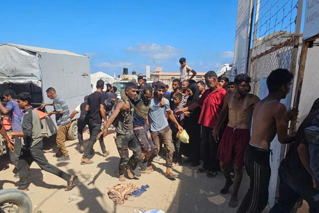 EDITORS NOTE: Graphic content / Palestinians transport a victim to a Red Cross clinic in Rafah in the southern Gaza Strip after they were reportedly shot as they waited to receive food parcels at a distribution point run by the US and Israel-backed Gaza Humanitarian Foundation (GHF), on July 12, 2025. Gaza's civil defence agency said at least 14 Palestinians were killed in the latest wave of Israeli strikes across the territory on July 12. (Photo by AFP)