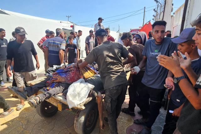 Palestinians transport victims to a Red Cross clinic in Rafah in the southern Gaza Strip after they were reportedly shot as they waited to receive food parcels at a distribution point run by the US and Israel-backed Gaza Humanitarian Foundation (GHF), on July 12, 2025. Gaza's civil defence agency said at least 14 Palestinians were killed in the latest wave of Israeli strikes across the territory on July 12. (Photo by AFP)