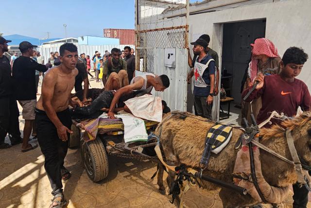 Palestinians transport victims to a Red Cross clinic in Rafah in the southern Gaza Strip after they were reportedly shot as they waited to receive food parcels at a distribution point run by the US and Israel-backed Gaza Humanitarian Foundation (GHF), on July 12, 2025. Gaza's civil defence agency said at least 14 Palestinians were killed in the latest wave of Israeli strikes across the territory on July 12. (Photo by AFP)