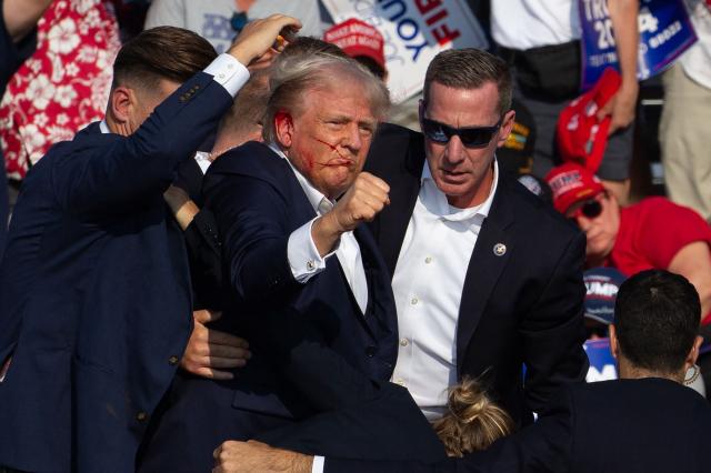 (FILES) US Republican candidate Donald Trump is seen with blood on his face surrounded by secret service agents as he is taken off the stage at a campaign event at Butler Farm Show Inc. in Butler, Pennsylvania, on July 13, 2024. Trump says "mistakes were made" but he's satisfied with the investigation into his near-assassination a year ago, as the Secret Service announced disciplinary actions on July 10, 2025 against six staff members. In excerpts of an interview on Fox News' "My View with Lara Trump" show, airing on July 12, Trump, 79, said the elite close-protection service "had a bad day." (Photo by Rebecca DROKE / AFP) / QUALITY REPEAT