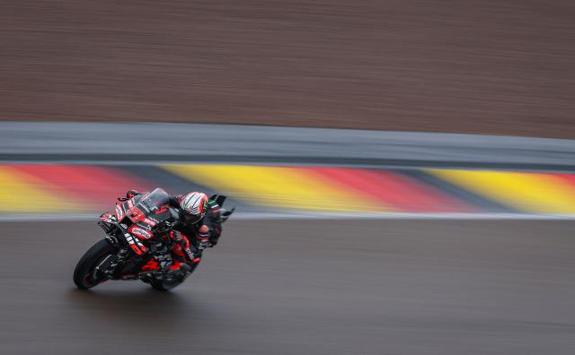 Aprilia Racing team's Italian MotoGP rider Marco Bezzecchi  steers his bike during the third practice session of the MotoGP German motorcycle Grand Prix at the Sachsenring racing circuit, in Hohenstein-Ernstthal near Chemnitz, eastern Germany on July 12, 2025. (Photo by Ronny Hartmann / AFP)