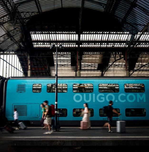 People walk on a platform along a Ouigo train at the gare de Lyon train station in Paris on July 12, 2025. (Photo by Guillaume BAPTISTE / AFP)