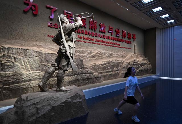 A girl runs next to a statue as people visit the memorial site of the full outbreak of the Chinese People's War of Resistance Against Japanese Aggression in Beijing on July 12, 2025. China's government on July 7, marks the 80th anniversary of the end of China's War of Resistance Against Japanese Aggression. (Photo by Adek BERRY / AFP)