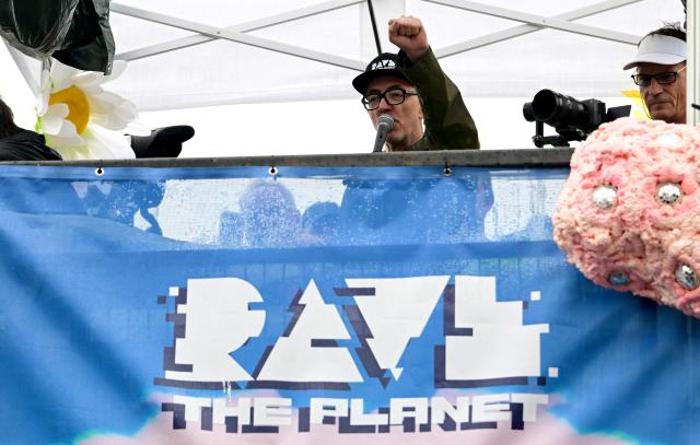 German DJ Dr Motte clenches his fist as he greets participants during the "Rave The Planet" electronic music parade titled "Our Future is Now" in Berlin on July 12, 2025 in Berlin. (Photo by Tobias SCHWARZ / AFP)