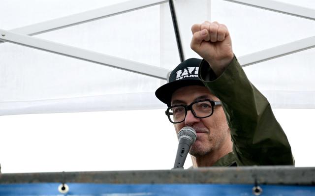 German DJ Dr Motte clenches his fist as he greets participants during the "Rave The Planet" electronic music parade titled "Our Future is Now" in Berlin on July 12, 2025 in Berlin. (Photo by Tobias SCHWARZ / AFP)