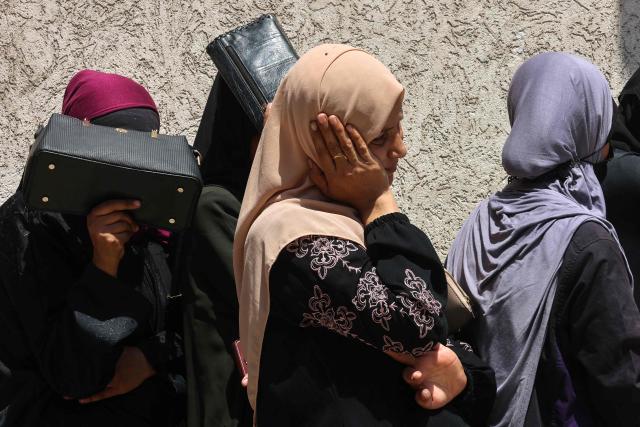 TOPSHOT - Palestinian women line up to receive bags of flower at a UN World Food Programme (WFP) warehouse on Al-Jalaa street in Gaza City, in the central Gaza Strip on July 12, 2025. Indirect talks between Hamas and Israel for a ceasefire in Gaza are being held up by Israel's proposals to keep troops in the territory, two Palestinian sources with knowledge of the discussions told AFP on July 12. (Photo by Omar AL-QATTAA / AFP)