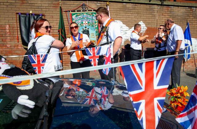 Members of Orange Order wait to take part in a parade in Belfast on July 12, 2025, to celebrate the battle of the Boyne in 1690, when the Protestant King William of Orange defeated the Catholic King James. (Photo by PAUL FAITH / AFP)