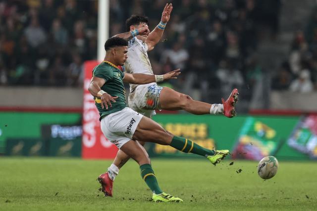 South Africa's fly-half Sacha Feinberg-Mngomezulu (L) kicks the ball away from Italy's centre Tommaso Menoncello (R) during the international rugby union Test match between South Africa and Italy at Nelson Mandela Bay Stadium in Gqeberha on July 12, 2025. (Photo by PHILL MAGAKOE / AFP)