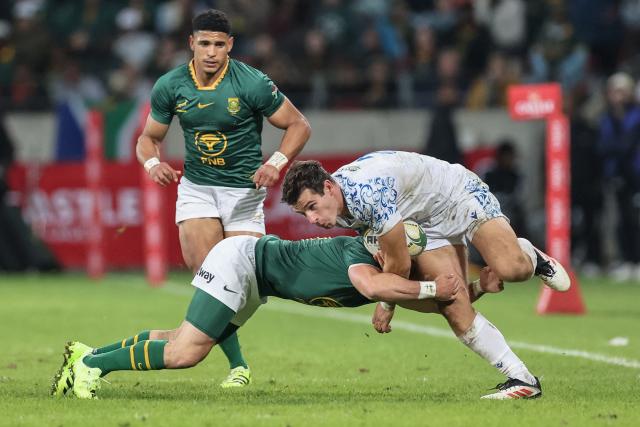 South Africa's loose forward Cobus Reinach (C) tackles Italy's fullback Giulio Bertaccini (R) during the international rugby union Test match between South Africa and Italy at Nelson Mandela Bay Stadium in Gqeberha on July 12, 2025. (Photo by PHILL MAGAKOE / AFP)
